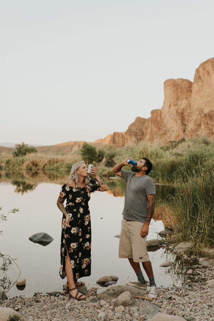 Engaged Couple take photos while drinking beer at the Salt River